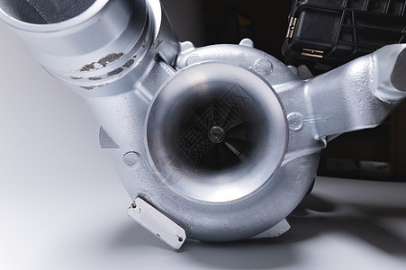 新的涡轮充气机 有铝冷部分 以灰色对比背景 汽车发动机涡轮充电器 零配件运输压缩机速度机械金属车辆管道白色技术力量图片