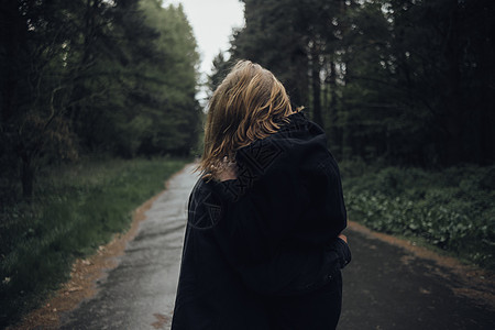 在雨天中拥抱在森林中的爱人树木黑色男人胡须金发女郎潮人女士乐趣夫妻绿色背景图片