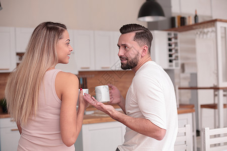 梦想着一对年轻夫妇 站在他们的厨房里女性压痛时间女士咖啡杯子房子早餐朋友们夫妻图片