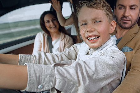 快乐的儿子驾驶汽车假期男人家庭座位窗户车辆运输父亲教育女士图片