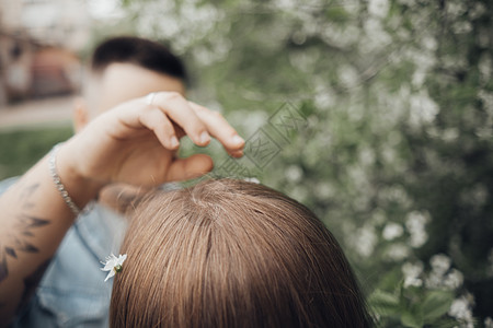 一个人在心爱的人的头发里安排花朵休闲装太阳乐趣微笑拥抱红发两个人喜悦男性男朋友图片