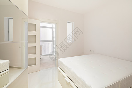 白色卧室 有床 衣柜和浴室入口 位于现代翻新的公寓内 随时可以租用图片