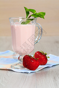 杯酸奶 桌上有薄荷和新鲜草莓图片