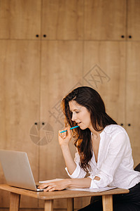 坐在办公室用笔记本电脑工作的漂亮女士微笑女孩技术工人商务人士黑发商业成人中心图片