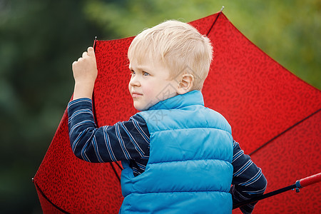 一个小男孩的红色大雨伞形象图片