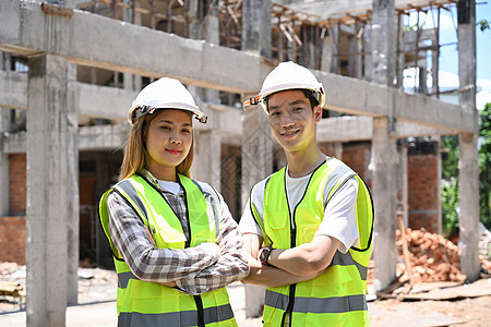 建筑工地有两名建筑师手牵手臂跨过大楼建筑工地图片