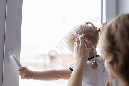 母亲修理女儿的人工耳蜗助听器  耳聋和多样性概念 治疗耳聋的创新技术耳朵配饰损失婴儿药品助听器少数民族成人乐器保健图片