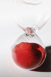 带有红色沙子的白玻璃杯白色古董沙漏时间测量小时玻璃宏观商业倒数图片