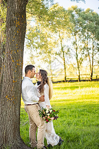 幸福的年轻夫妇在他们的婚礼那天在绿色麦田 微笑的新婚夫妇手牵着手走在大自然中 家庭生活 婚礼概念图片