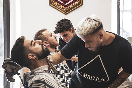 剪胡子和头发的专业理发师男人工作客户理发店剪刀护理发型师顾客沙龙发型图片