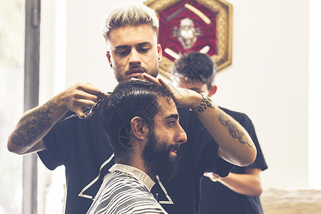 剪胡子和头发的专业理发师男人剃刀顾客职业发型沙龙专注服务胡须男性图片