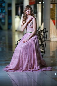 穿着粉红色长裙的金发美女 坐在金属板凳上魅力晚礼服女人刺绣胡子衣服艺术大厅礼服女装图片
