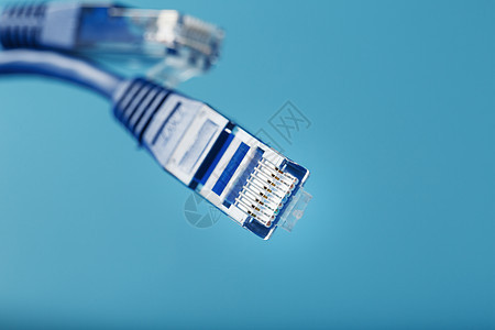 Ethernet两台电缆连接器 断线索紧闭 以蓝背景隔离 空闲空间电讯电脑带宽服务器港口绳索商业塑料宽带网络图片