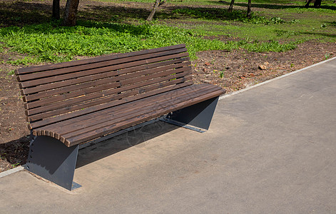 明春日 城市公园的木棕色长椅校园阳光椅子园艺城市街道公园家具闲暇生活图片
