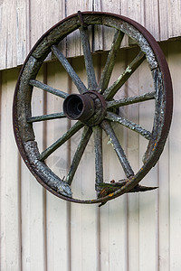 老式木制马车车轮 木背景 挂在谷仓上的旧木车轮图片