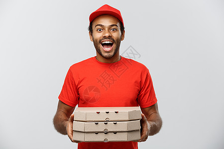 交付概念英俊的非裔美国人披萨运送者的肖像 孤立在灰色工作室背景上 复制空间手臂导游礼物男性工人工作红色相机职业男人图片
