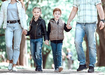 在公园散步时 有两个孩子的家庭母亲童年树木喜悦父母女性享受乐趣父亲闲暇图片