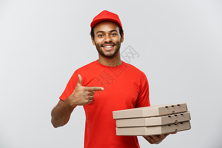 交付概念非洲快乐美国人送货人的肖像 指手展示披萨盒包 孤立在灰色工作室背景上 复制空间 笑声工人工作男性红色男人手指男生成人手势图片