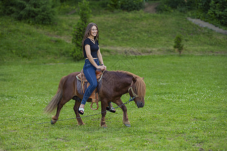 女孩骑小马骑士童年马术场地农场阳光朋友们幸福活动女性图片