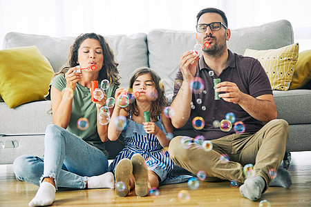 儿女女儿家庭快乐母亲父亲一起玩乐 在家里吹肥皂泡沫气泡气球图片