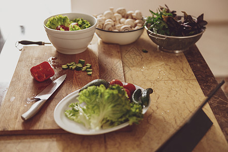 餐桌边有厨房板 绿菜和蘑菇 放在碗里图片