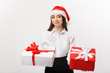 圣诞节概念  年轻快乐的白人女商务人士戴着圣诞老人的帽子 可以选择礼品盒给相机 旁边有复印空间网上购物男性商务下巴胡子新年销售礼图片