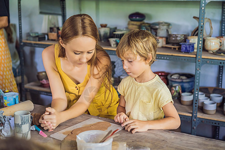 母亲和儿子在陶瓷车间做陶瓷锅围裙女孩艺术学习制品工艺绘画男生工匠幸福图片