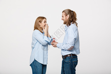 提案概念男人在孤立的白色背景下向他美丽的女朋友展示订婚戒指钻石的肖像石头男朋友情人婚姻妻子首饰周年丈夫盒子纪念日图片