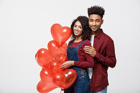 有吸引力的非裔美国人夫妇 拥抱并抱着红心气球 笑声女朋友闲暇乐趣夫妻纪念日展示男人微笑幸福孩子图片