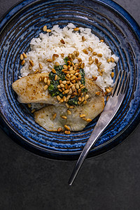 白鳕鱼与自制的烤虫和烤松子内核盘子白色蔬菜香蒜松树海鲜胡椒健康美食午餐图片