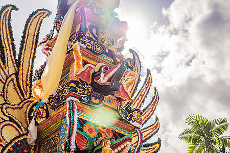 印度尼西亚巴厘岛乌布德市中央街道上 传统恶魔的拜林树雕塑和鲜花组成的巴德火化塔 为即将到来的火化仪式做准备上帝信仰宗教艺术旅行寺图片