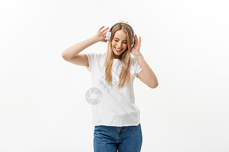 生活方式概念 一个开朗快乐的女学生的肖像 一边戴着耳机一边跳舞 一边在白色背景下与世隔绝玩家舞蹈技术成人女孩青少年幸福喜悦乐趣电图片