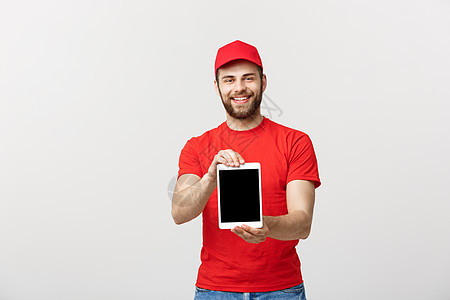 在线购物 送货 技术和生活方式概念微笑的送货员在他的手上展示平板电脑 展示一些东西 孤立在白色工作室背景药片男人邮政包装服务纸板图片