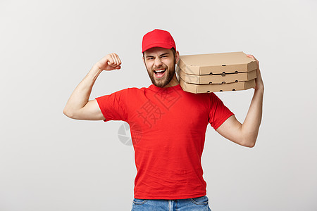交付概念强健英俊送货员的肖像 他伸展肌肉并拿着披萨盒包 孤立在灰色工作室背景上 复制空间衬衫包装成人盒子展示男人商业胡须工作邮递图片