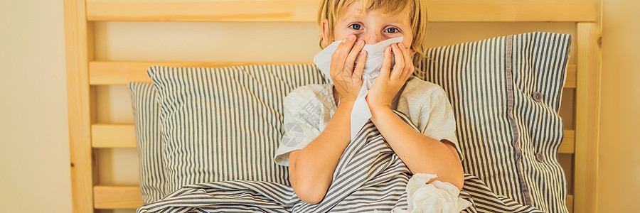 生病的男孩咳嗽和擦擦鼻子 在床上发烧和生病的患病儿童;图片