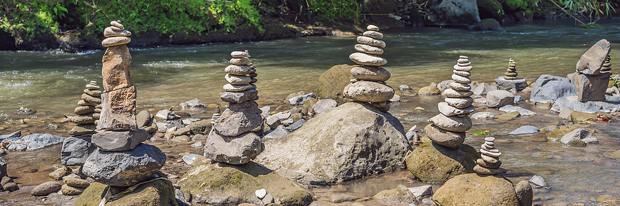 Inuksuk土著Rock Pile 在一个溪口银行图片