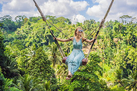 年轻女子在印度尼西亚巴厘岛的丛林雨林中荡秋千 在热带摇摆 秋千巴厘岛的潮流头发瀑布旅游冒险天空女孩乌布荒野闲暇风景图片