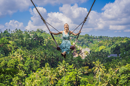 年轻女子在印度尼西亚巴厘岛的丛林雨林中荡秋千 在热带摇摆 秋千巴厘岛的潮流绳索环境海滩旅行顶峰瀑布天空座位青少年女孩图片