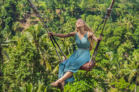 年轻女子在印度尼西亚巴厘岛的丛林雨林中荡秋千 在热带摇摆 秋千巴厘岛的潮流树屋假期瀑布绳索游客天空森林环境旅行乌布图片