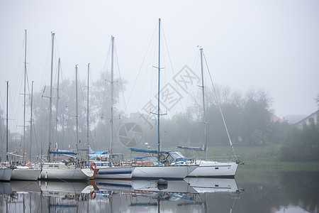 游艇是停泊在码头的小型船只 在浓雾中观望 旧港口图片
