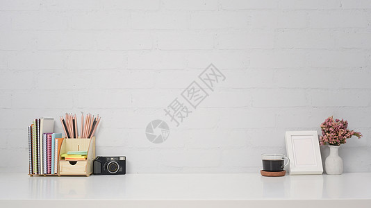 文具框时髦的工作场所 有照相机 咖啡杯 图片框和白桌上的文具背景