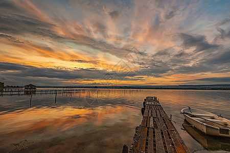 在湖边的湖边 在木头码头有一条船海滩海岸天空情绪钓鱼阳光日落反射戏剧性图片