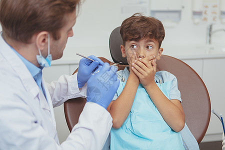 迷人的年轻男孩在牙医处接受牙齿检查精神考试保健卫生员工作痛苦预防口腔科愈合访问图片