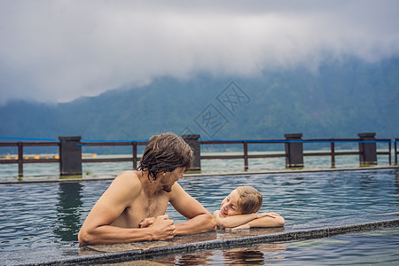 父亲和儿子旅行者在巴厘岛温泉的湖边背景 与儿童一起旅行概念纪念碑喷泉水池女士雕像孩子文化地标传统洗澡图片