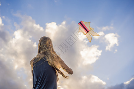 年轻女人在海滩上放风筝 梦想 愿望 未来计划假期天空女性气候蓝色成人活动追求飞行风筝图片