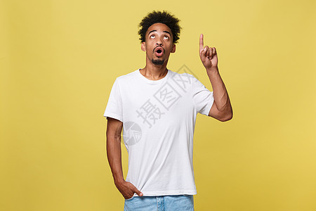 年轻英俊的非裔美国人 在黄色背景上向上走去手指手势广告灰色白色黑色微笑男人男性青年图片
