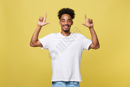 年轻英俊的非裔美国人 在黄色背景上向上走去微笑灰色手势成人青年男性广告黑色男人快乐图片