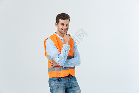 带着橙色背心的快乐年轻工匠肖像 在白色背景上被隔离领班头盔工人安全帽经理成人男性建筑师帽子职业图片