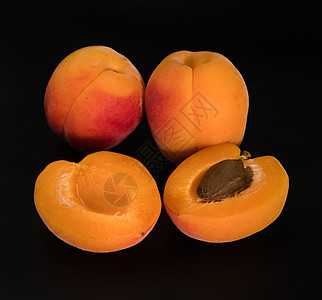 一大堆成熟的杏子水果 两整两块和两个分开的部分 在黑色背景上单独隔离图片