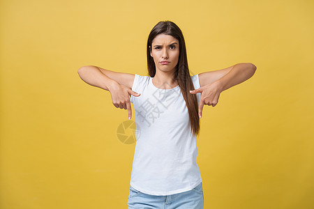 年轻非常不开心 严肃的女人特写肖像指着某人 好像在说你做错了什么 在黄色背景下被隔绝的严重错误 负面情绪 面部表情感觉牵连女性伤图片